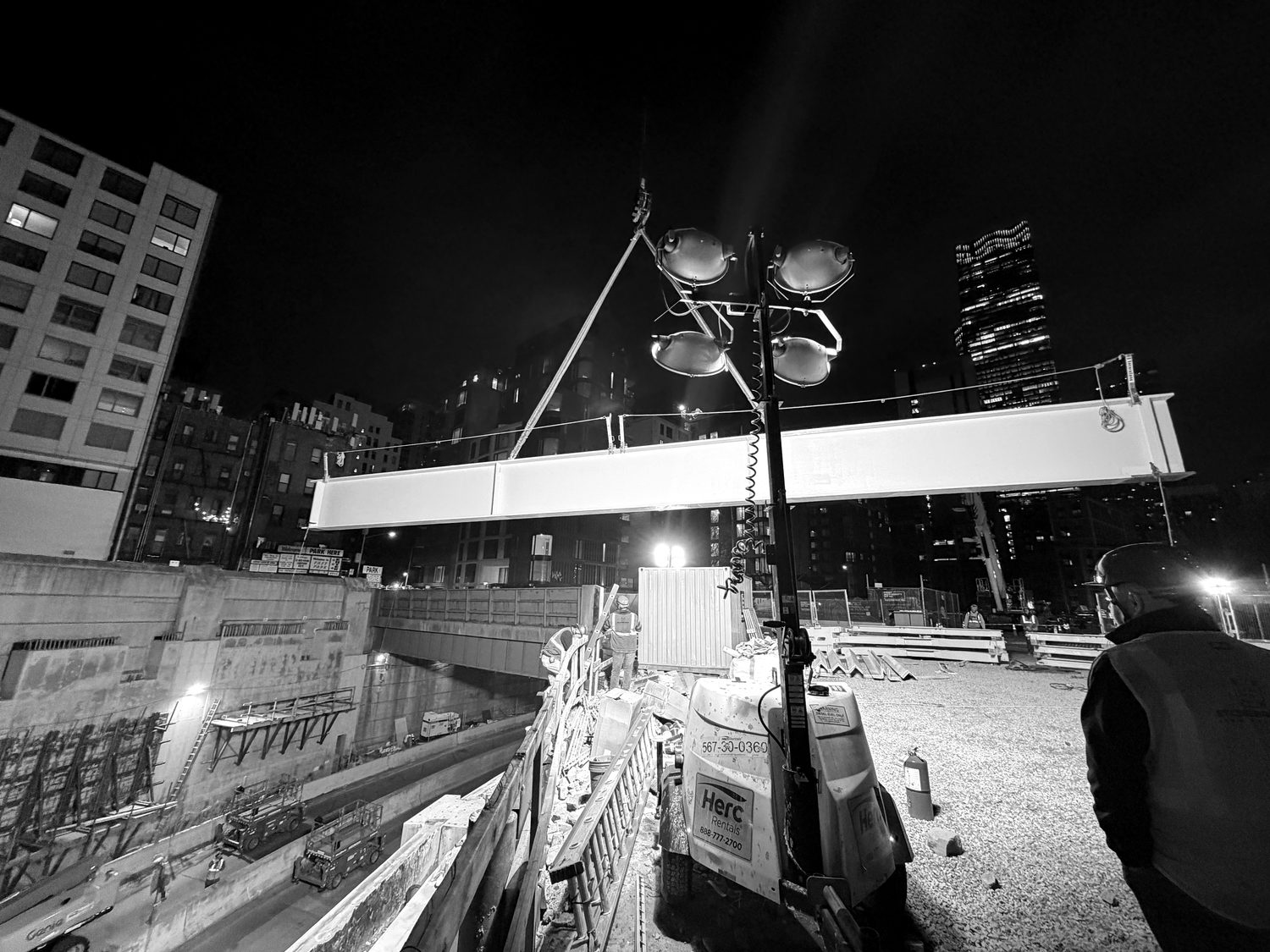 Nighttime structural steel lift over an active roadway